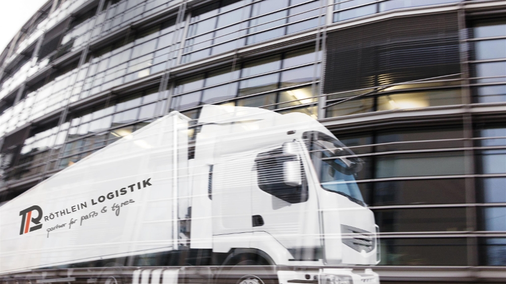 weißer Lkw vor einem Gebäude