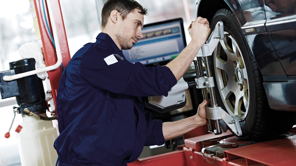 Mechaniker montiert einen Reifen an einem Auto
